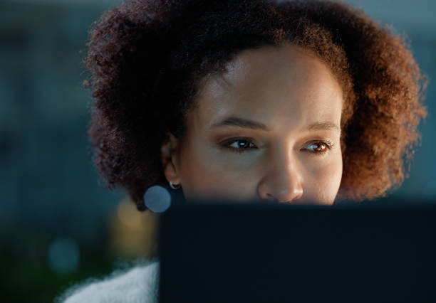 istock Laptop, reading and woman in office at night coding for cybersecurity, it or data information. Research, computer and female programmer working on software development with deadline in workplace. 2149038028