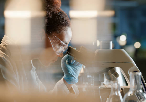 istock African woman, microscope and medical science in laboratory for research, analytics and medicine. Female scientist, working and experiment or study for results, virus vaccine, and innovation 2149039459