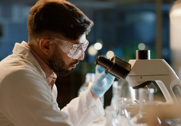 istock Scientist, microscope and analysis in lab for medical study, innovation and stem cell research. Man, science experiment and investigation with biotechnology for dna, knowledge or testing for bacteria 2149039468