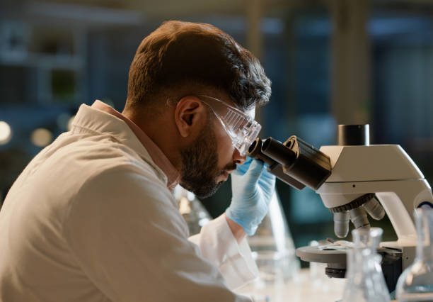 istock Scientist, microscope and analysis in lab for chemistry study, innovation or pharmaceutical research. Man, experiment and investigation with biotechnology for clinical trial, development or knowledge 2149039470