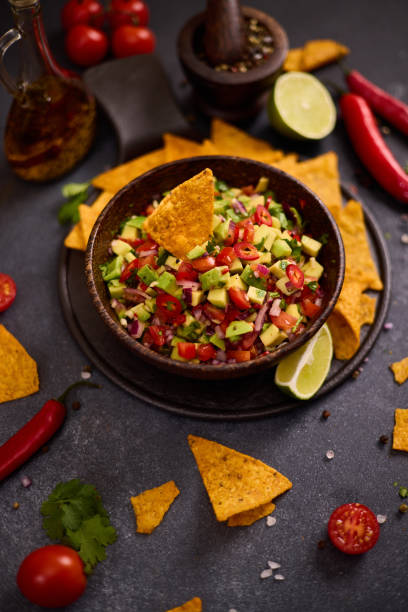 istock traditional salsa dip snack in wooden bowl and corn nacho chips on a table with ingredients 2149040505