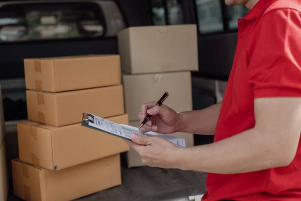 istock Delivery man, boxes and logistics concept A parcel or courier service stands at the front door of a service provider or product for online purchases, shipping or e-commerce. Close-up pictures 2149042347