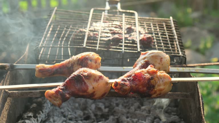 Beef steak is cooked on the grill. Chicken legs on skewers. Selective Focus