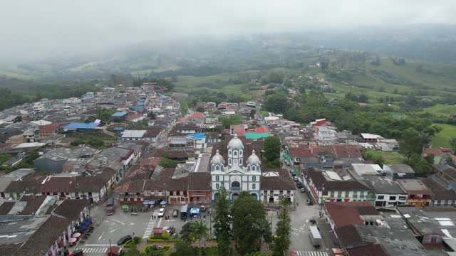 Reveal shot of Parque Bolivar and the church Parroquia Inmaculada Concepción de Filandia in the Andean town of Filandia in the Quindío department of Colombia