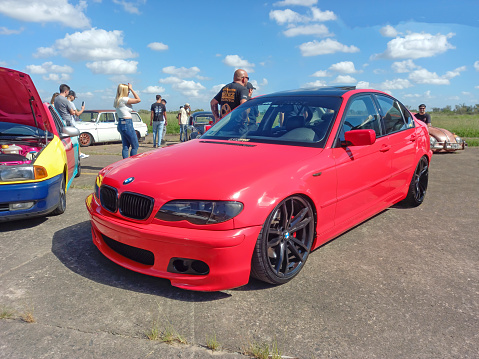 Morón, Argentina - Apr 7, 2024: Old shiny red BMW 3 Series E46 330d sedan 2003 - 2006 at a classic car show in an airfield.