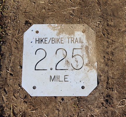 A close view of the dirty metal distance sign on the concrete.