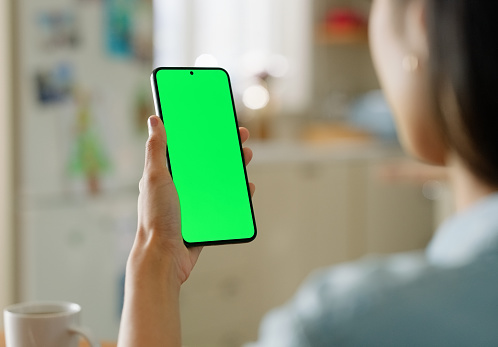 Hands, woman and green screen phone in house for streaming social media, news or video at home. Smartphone, mockup or female person with space for app, film or subscription service, menu or sign up