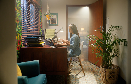 Computer, home office and woman at desk for online career, networking or creative freelancer. Thinking, project and remote work, girl at table for reading research notes or article review on website