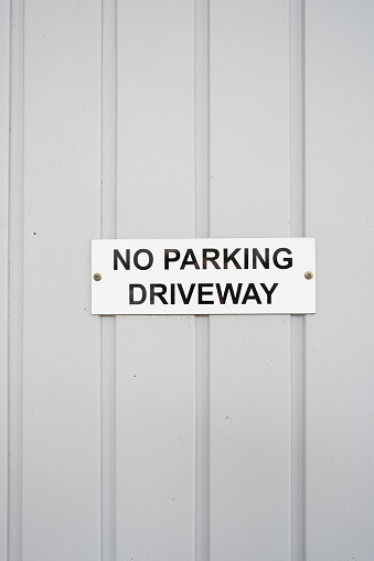 No parking in driveway sign on a metal garage door.