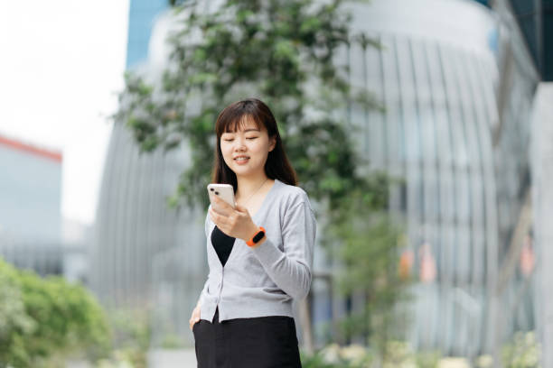 istock Young Asian business using smartphone in modern business district 2149052321