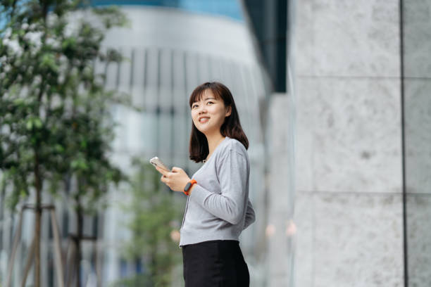 istock Young Asian business using smartphone in modern business district 2149052322