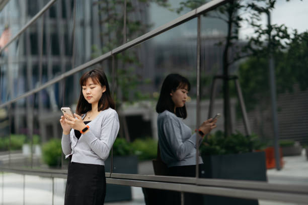istock Young Asian business using smartphone in modern business district 2149052330