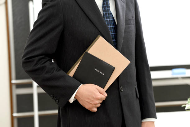 istock Businessman in a suit holding a notebook 2149054424