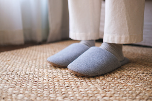 Closeup of a woman wearing slippers at home