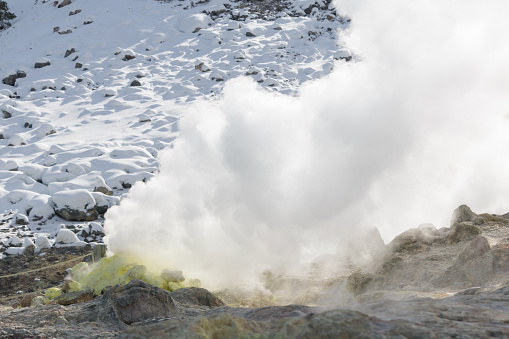 Close up of steam cloud rising from volcanic sulphur fumarole vent in winter landscape, Hokkaido, Japan