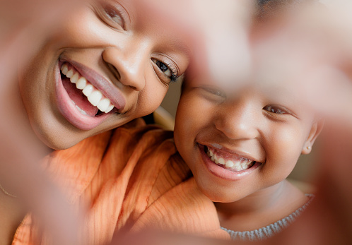 Smile, heart hands and black woman with child in portrait for  family, bonding and together on mothers day. Love, sign and mom with daughter, happy face and relax with support, growth and development