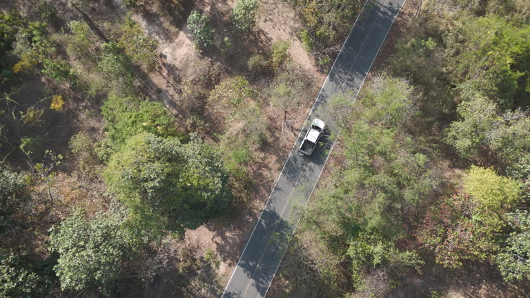 Drone footage aerial view scenic landscape of driving pickup truck deserted road in the rural place dry season