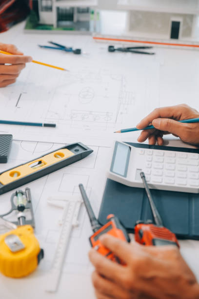 istock engineer people meeting working and pointing at a drawings in office for discussing. Engineering tools and construction concept. 2149058133