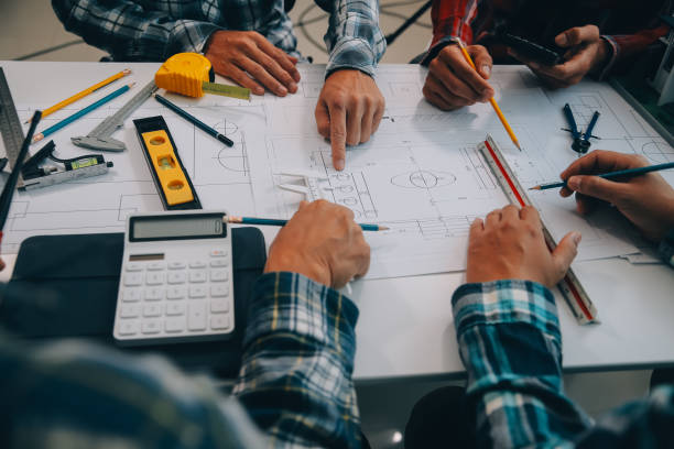istock engineer people meeting working and pointing at a drawings in office for discussing. Engineering tools and construction concept. 2149058139