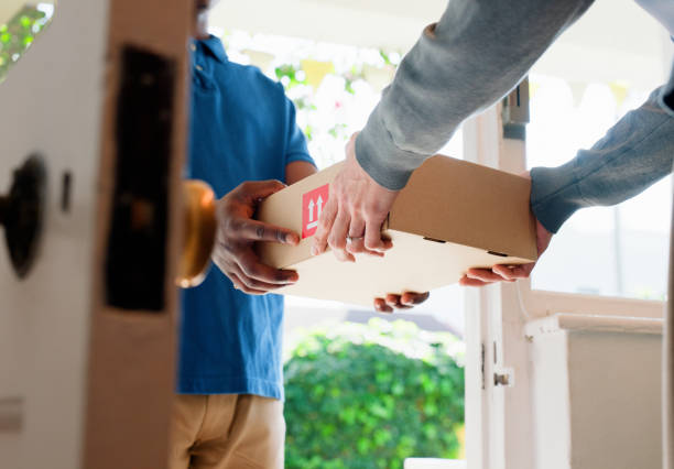 Hands, box and delivery man at front door in home with client, services and shipping for commercial product. People, courier and cardboard package for supply chain, logistics or distribution at house