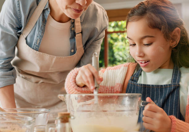 istock Child, mom and baking in kitchen with smile, teaching and learning with love, bonding and care in home. Mixer, mother and daughter with bowl for cooking, ingredients and development in family house 2149058674