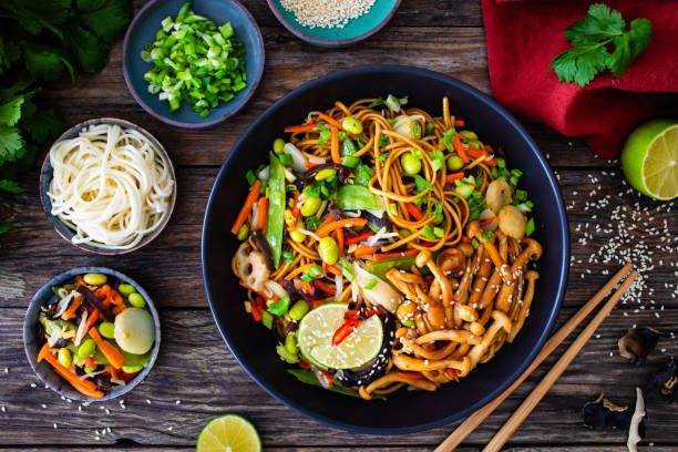 istock Asian style stir fried vegetables and noodles on wooden table 2149058817