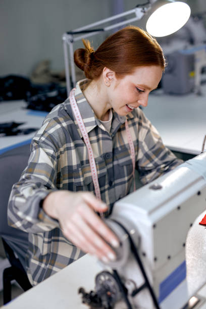 istock caucasian seamstress in factory sewing using industrial sewing machine, very accurate 2149058916