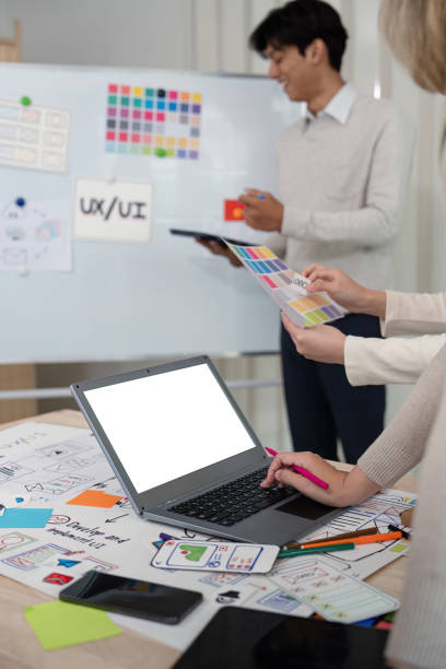 Designer team recommends color while mockup laptop display UI and UX designs for mobile app and website. Creative design and business concept