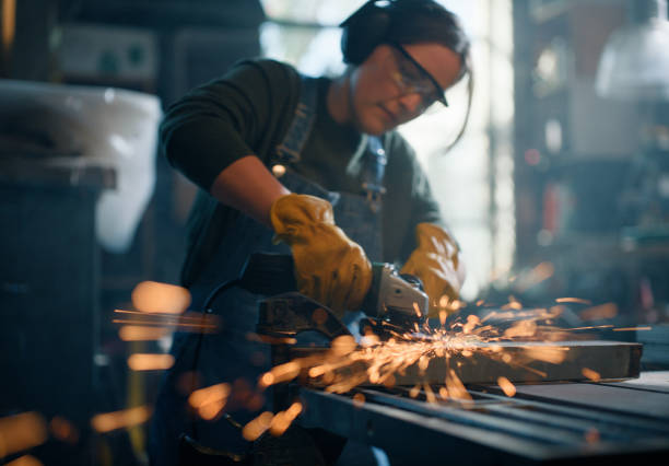 istock Woman, grinder and metal work in workshop production with sparks for welding skill, manufacturing or repair. Female person, power tools and electric in warehouse for manual labor, craft or industrial 2149061320