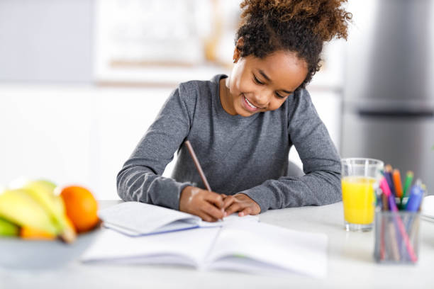 istock Happy black girl writing her homework at home. 2149064079