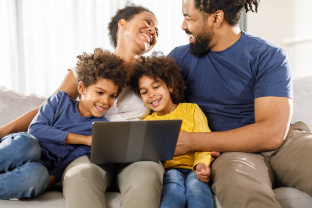 istock Happy black family using laptop on sofa at home. 2149064091