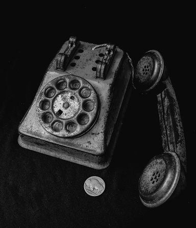 Old antique toy phone and a Buffalo nickel.