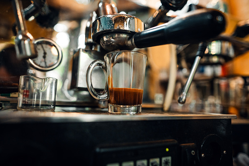 Fresh espresso shot pouring out of machine