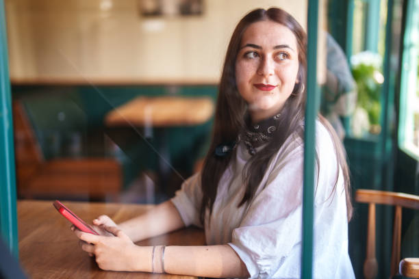 istock Young woman using mobile phone on table in a restaurant. 2149066463