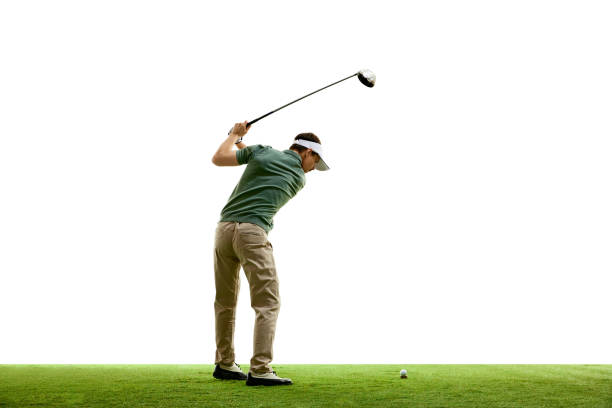 Rear view portrait of young athletic man, professional golfer playing golf on green lash grass against white studio background. Rear view portrait of young athletic man, professional golfer playing golf on green lash grass against white studio background. Concept of professional sport, luxury games, active lifestyle, action. golfer swinging club stock pictures, royalty-free photos & images