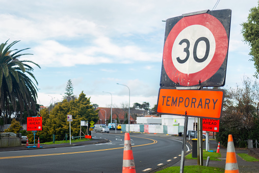 30km per hour road speed sign and orange traffic cones on the street. Roadworks in Auckland.