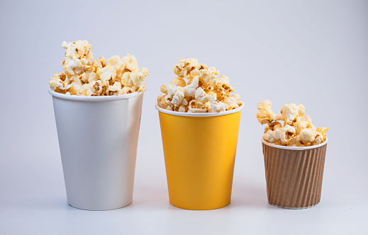Testy of popcorn in disposable paper buckets isolated on white background. Plastic free and Ecology concept.