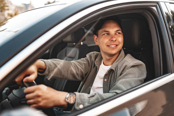 istock Young smiling man sitting in a car with open window 2149068816