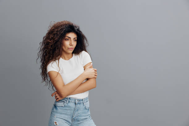 istock Curly serious smart confident happy caucasian woman 20s wearing white basic shirt hold hand crossed folded look aside isolated on plain gray background studio portrait. People lifestyle concept 2149069003