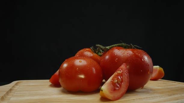 istock Macrography, slices of tomato placed on board with black background. Comestible. 2149069119