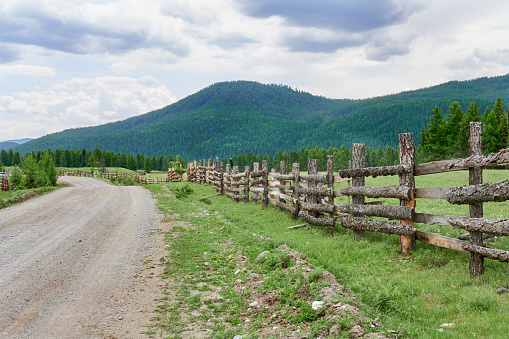 Wooden fence along the road in the Altai mountains, Russia