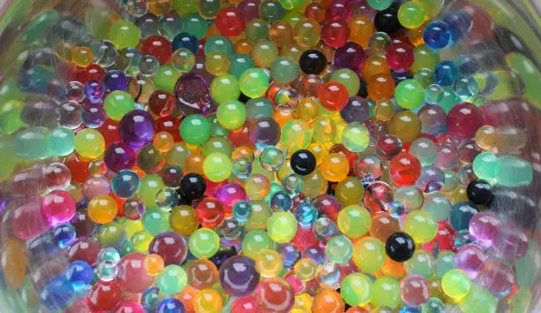 Colorful Gel Balls Inside Metal Bowl On White Surface