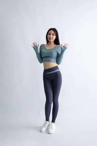 Asian woman in sportswear posing with hands up
