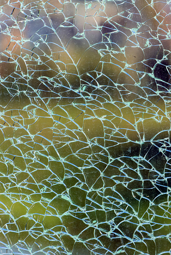 Abstract background of broken tempered glass of various shapes close up