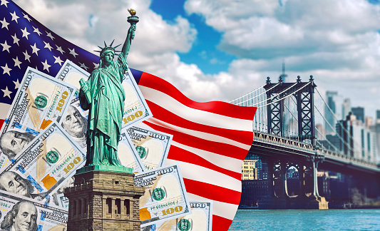 Statue of Liberty against the backdrop of the American flag, US dollar and Manhattan Bridge in New york city.