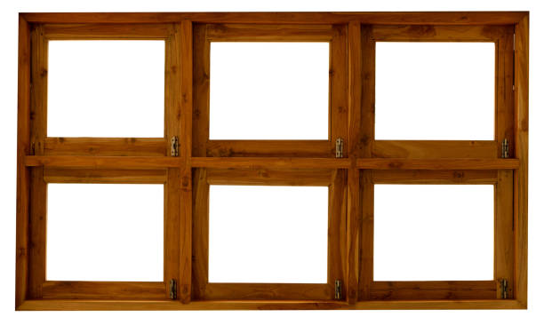 A rustic wooden window frame set into a textured plaster wall, reflecting an outdoor scene. The window's glass panes show a mix of blurred reflections and clear views of the exterior space, including greenery and wooden structures. The warm tones of the wood contrast with the earthy tones of the wall, creating a harmonious and natural aesthetic.