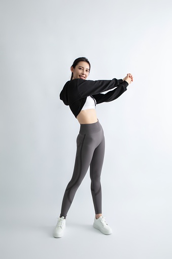 Asian woman in sportswear stretching arms