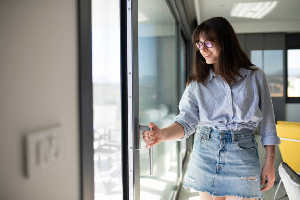 istock Young woman opening the balcony door. 2149073207