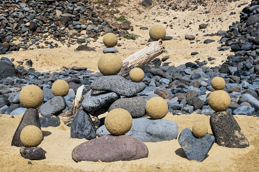 Zen activity consisting of creating a pyramid of driftwood pebbles and sand spheres