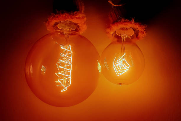 istock Edison light bulbs with a tungsten spiral in a vacuum close-up next to a concrete wall 2149074576